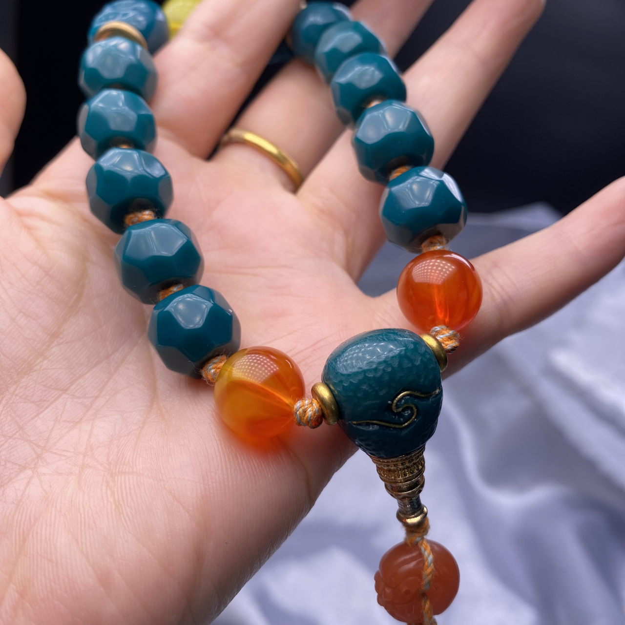 极品金龙山玉化牛油果绿无相珠手持,全品玉化通透,尺寸13×11mm,总重