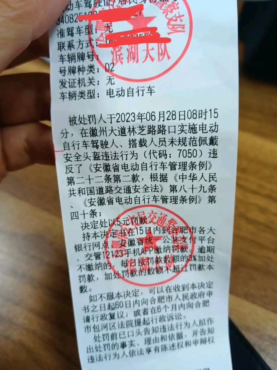 6月28日上午,骑电动车没戴头盔,直接被罚款5元.