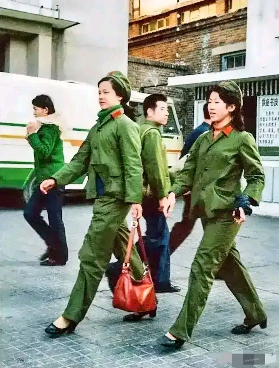 1970年,沈阳街头,两名身穿65式军装的女兵,英姿飒爽地仰首阔步,引来