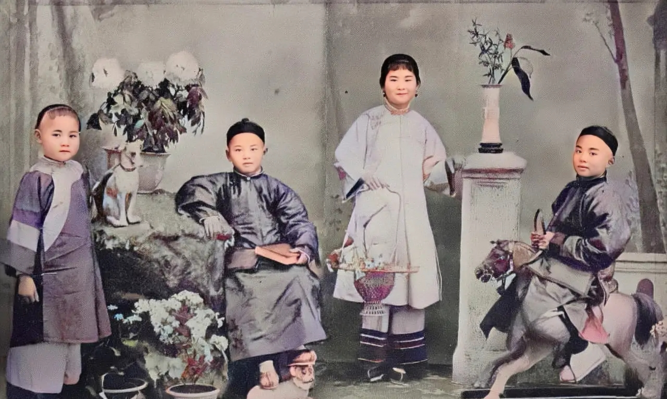 民国时期几位富家子弟的合影,照片中几个小孩穿着华丽整齐,中间提着