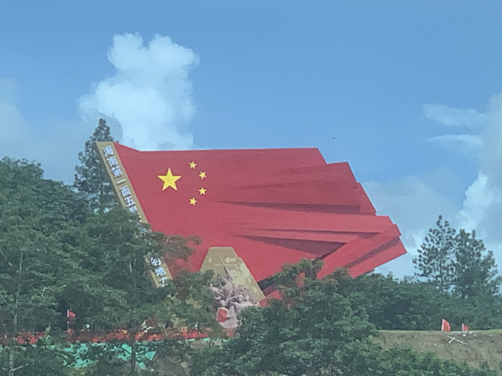 这是海三高速毛阳互通路口红色主题雕塑:二十三年红旗不倒!