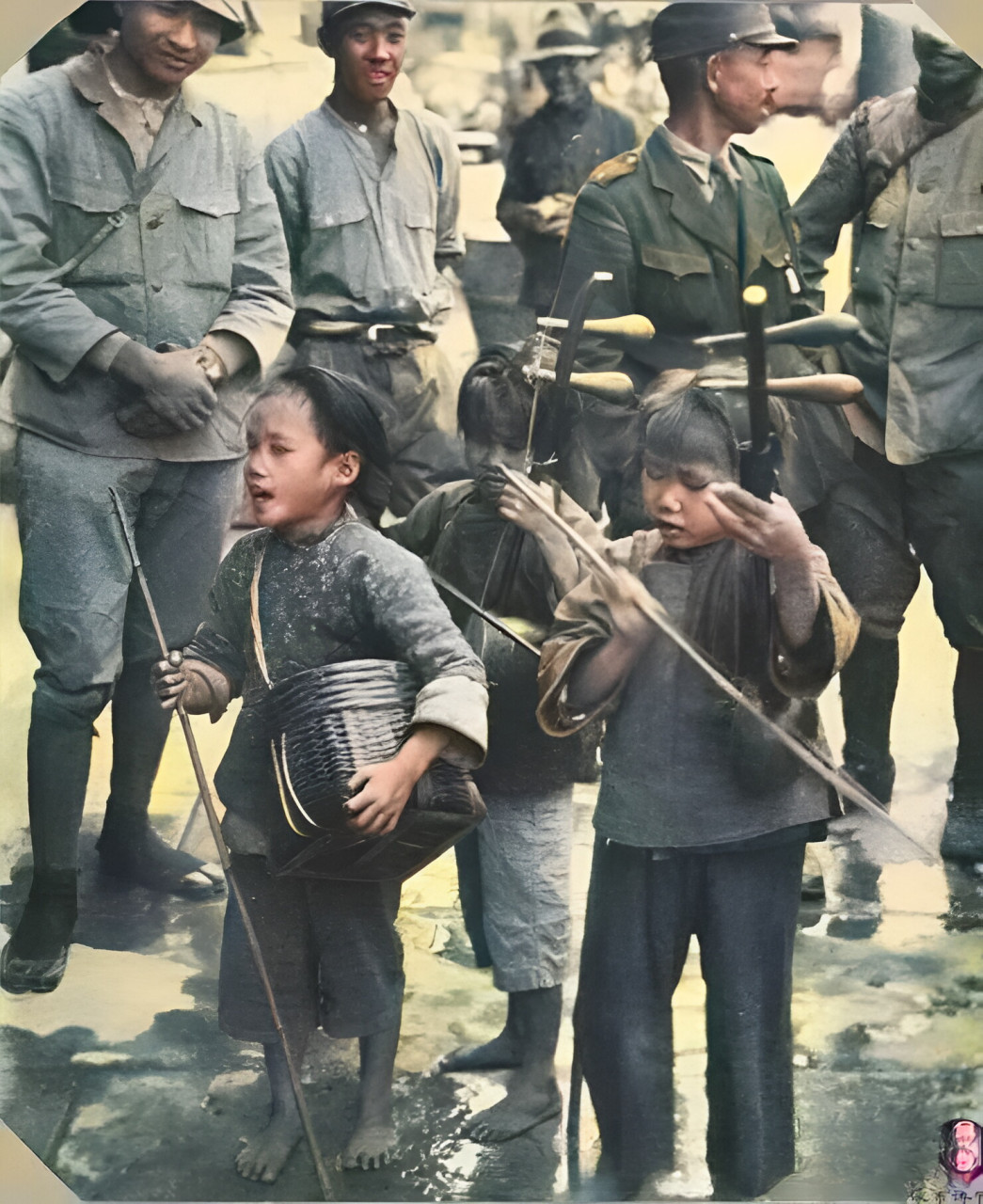 三个小女孩在街上卖艺,其中两个拉着二胡,前面的孩子背着一个小竹筒