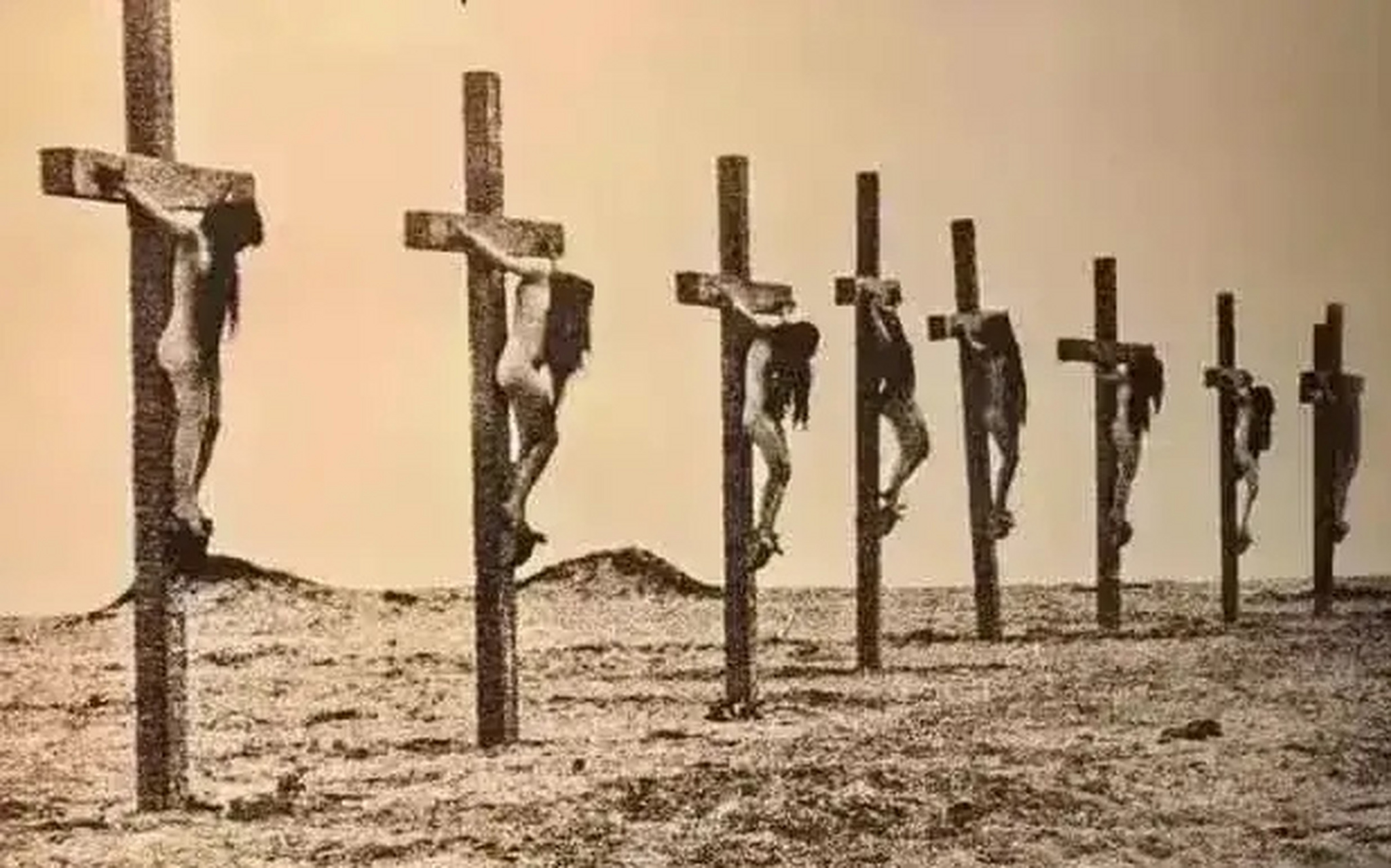 这是一张残忍的照片,只见几个女人赤身裸体,蓬头垢面被钉在十字架上