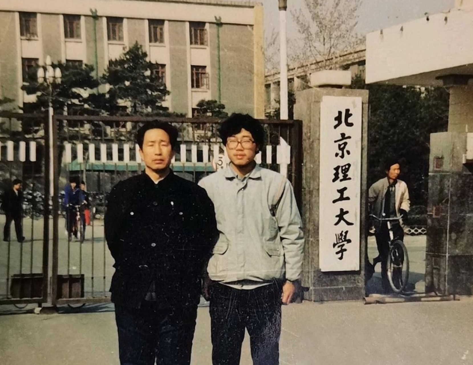 这张照片拍摄于1989年北京理工大学校门口,一对父子的合影