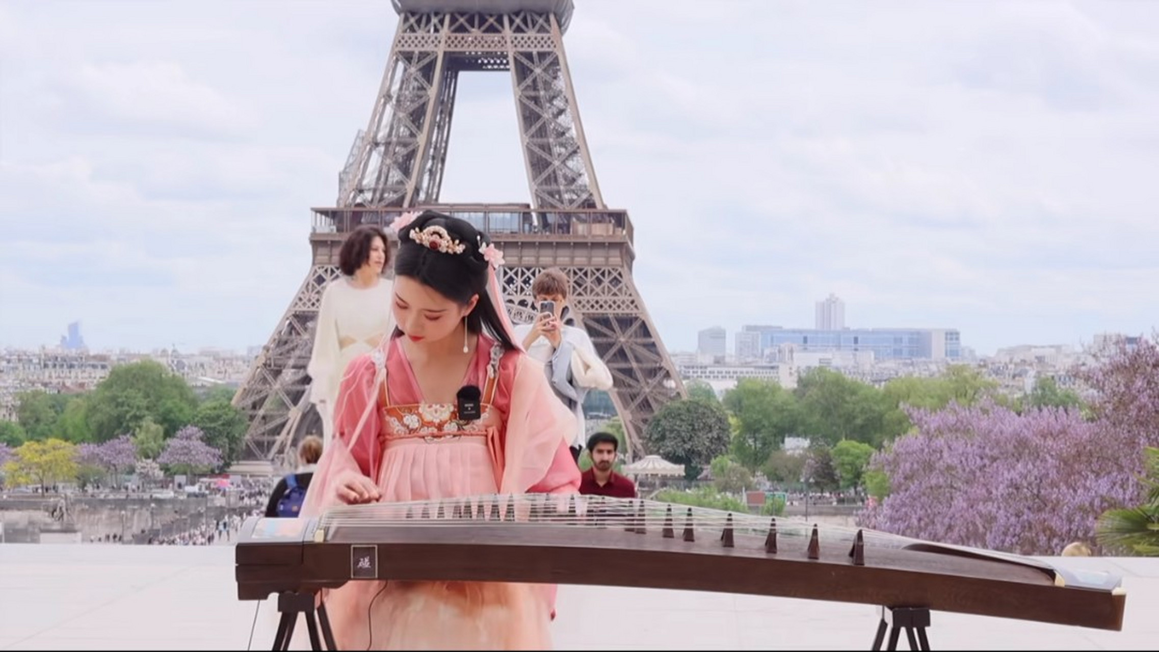 汉服# 在埃菲尔铁塔下,一袭汉服美女,弹奏的着悠扬的古筝,吸引问