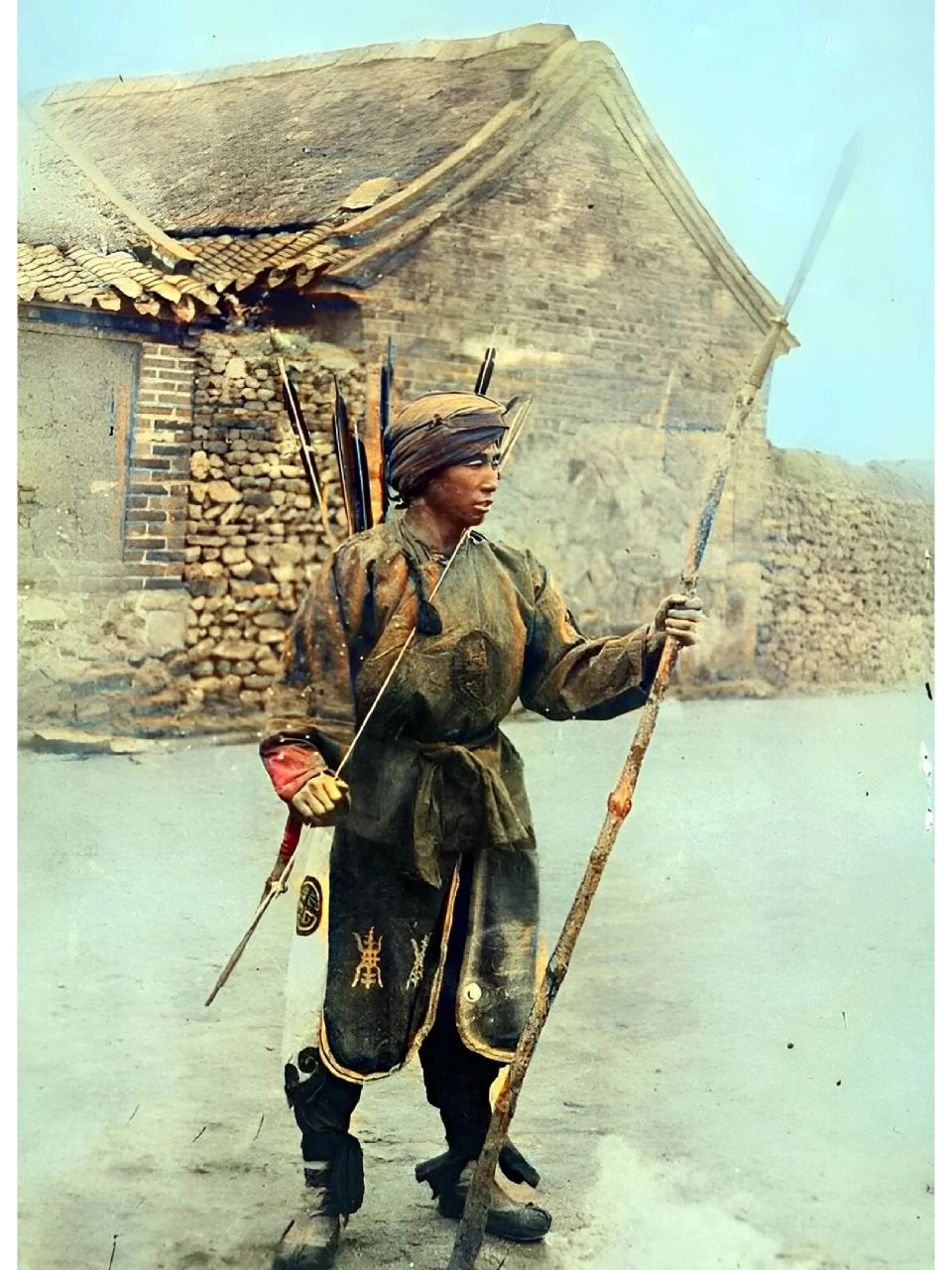 晚清,-名缠着头巾,身材高大的清兵正欣赏手中的兵器.