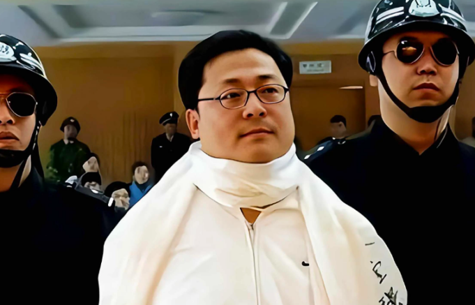 2006年,袁宝璟走下法庭,和妻子告别后,头戴白围巾被押上死刑车
