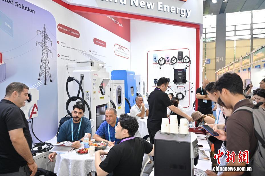 境外采购商在充电桩展位咨询洽谈（图源：中新社记者 陈楚红 摄）