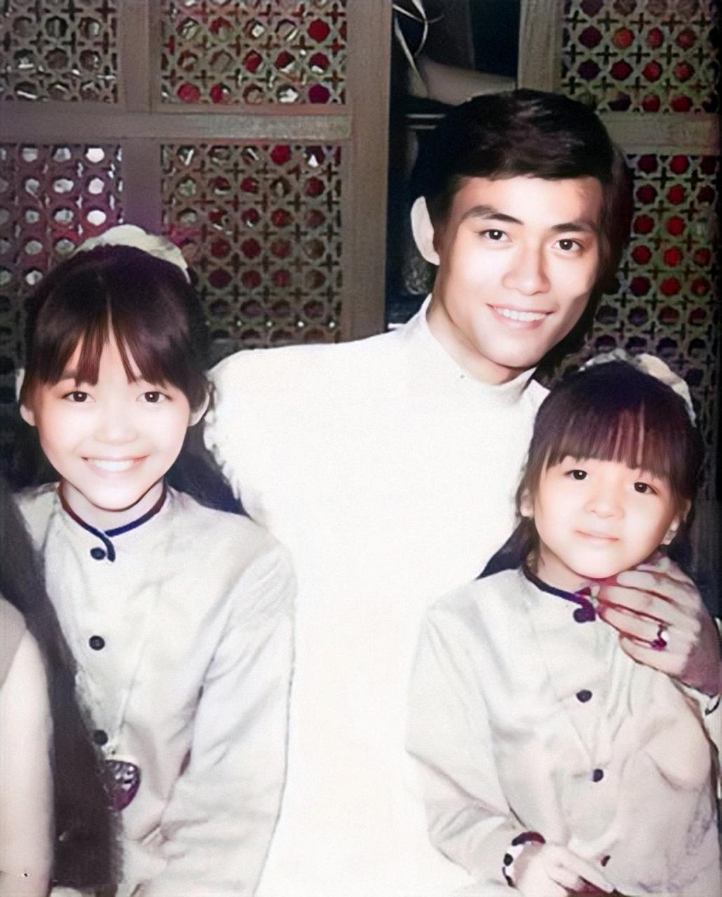 图为香港影星郑少秋抱着梅艳芳两姐妹的合照.