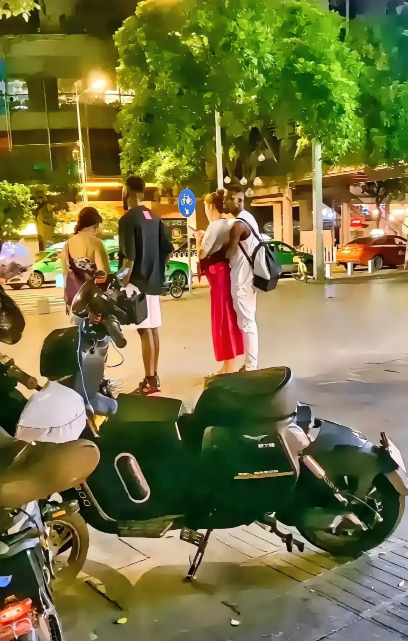 这是某地大街上,两个黑人和他们的中国女朋友一起逛街的情景.