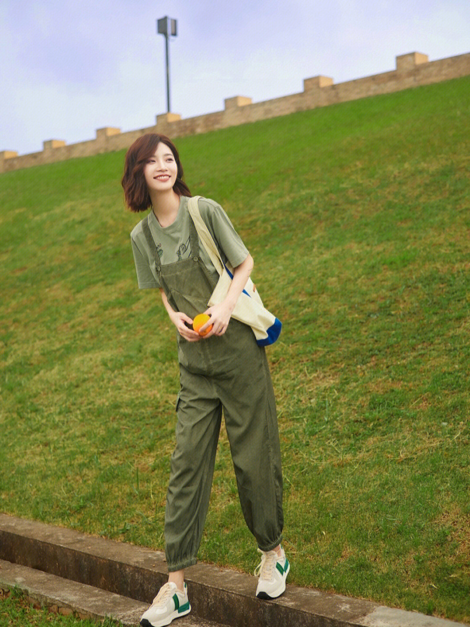 绿色清爽养眼又不挑肤色,一件绿色的短袖t恤搭配上墨绿色背带裤,简约