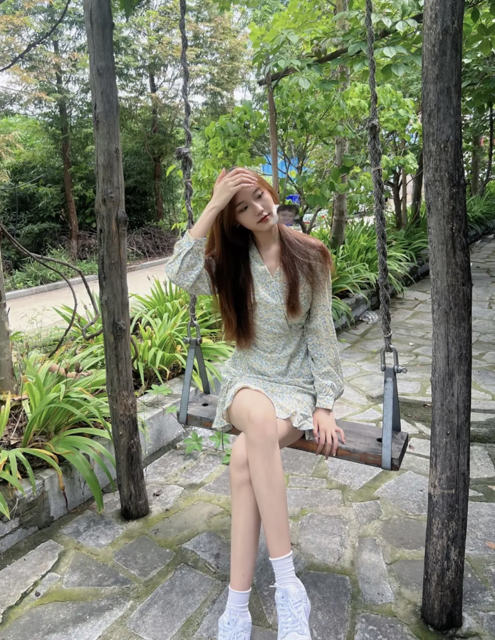 公园里荡秋千的身穿花色连衣短裙的大长腿性感美女