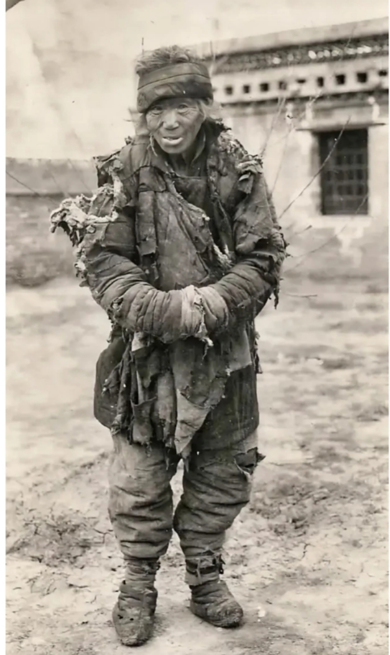 民国老照片,一位衣衫褴褛,饥肠辘辘的老乞丐,他身上的衣服也已经破得