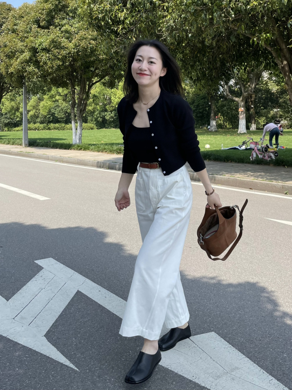 腰带搭配上黑色的针织开衫,简约成熟,下半身用白色的高腰阔腿裤来进行