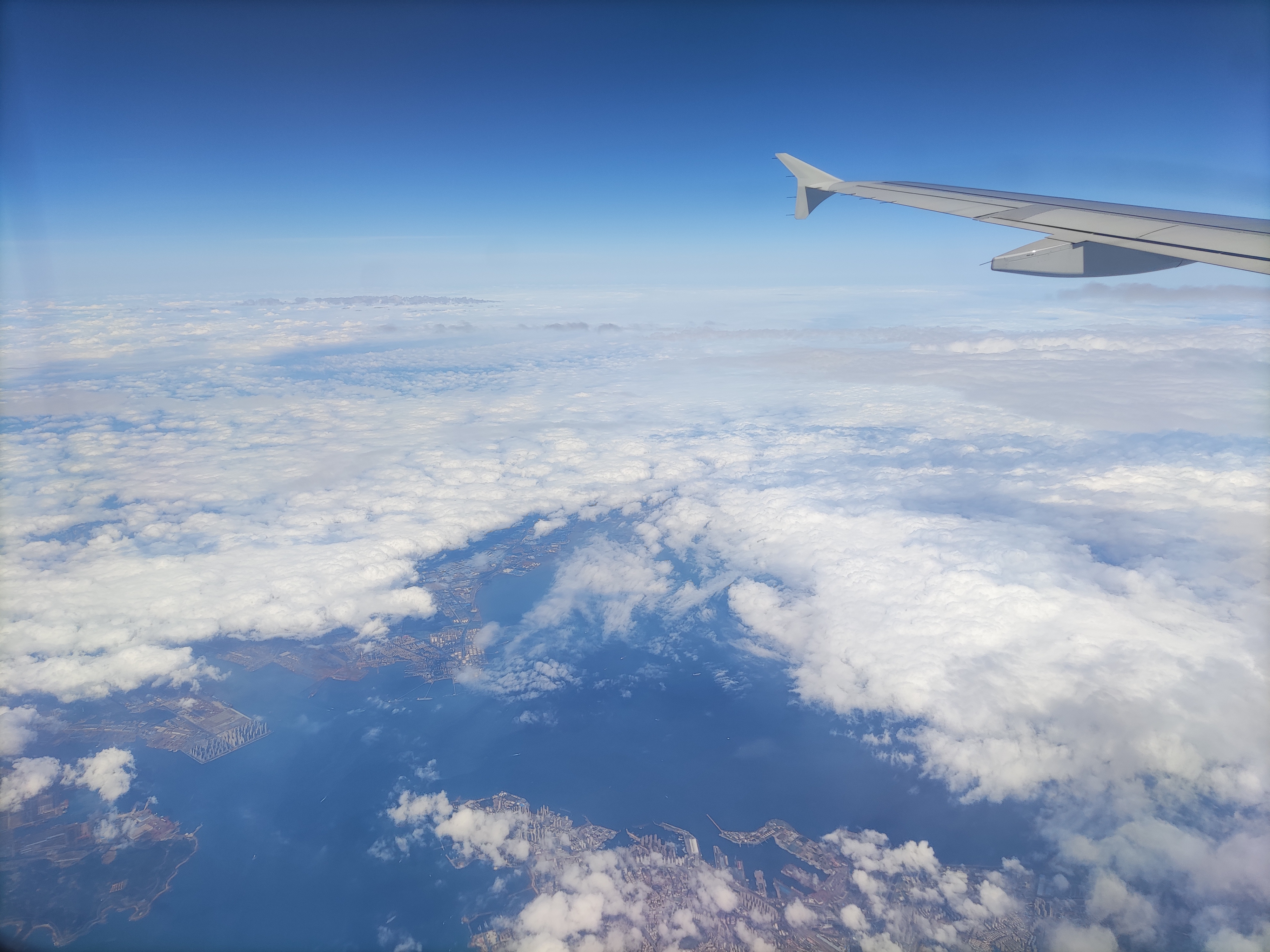 飞机上看蓝天白云,还有城市和大海,风景壮观