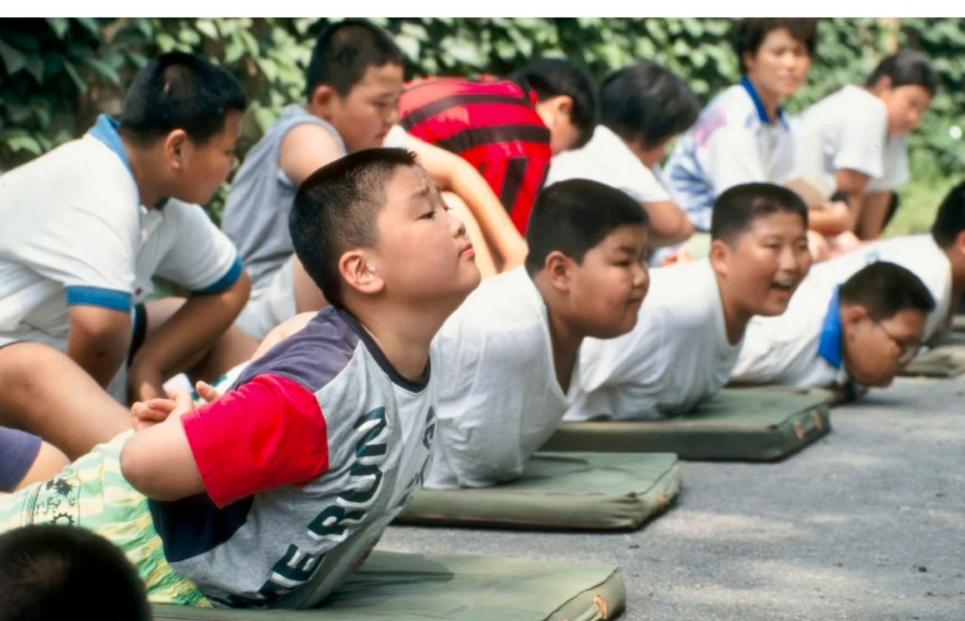 1994年,北京老照片,某小學正在上體育課,男同學正在壓肩,他們或許在