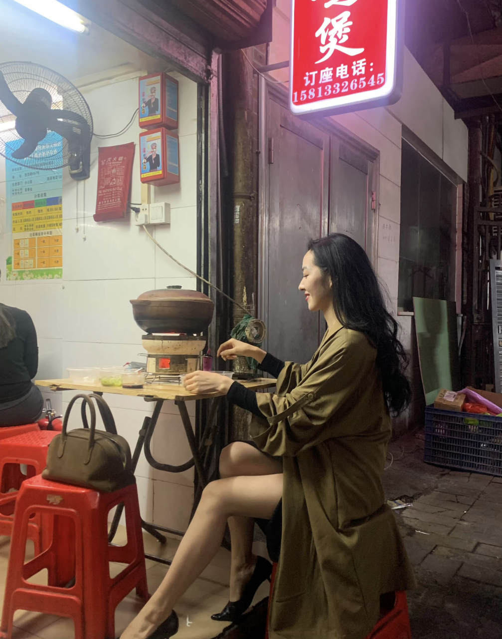 夜晚的小店一个大长腿美女独自坐在小店外面的餐桌上,一个人点餐一个