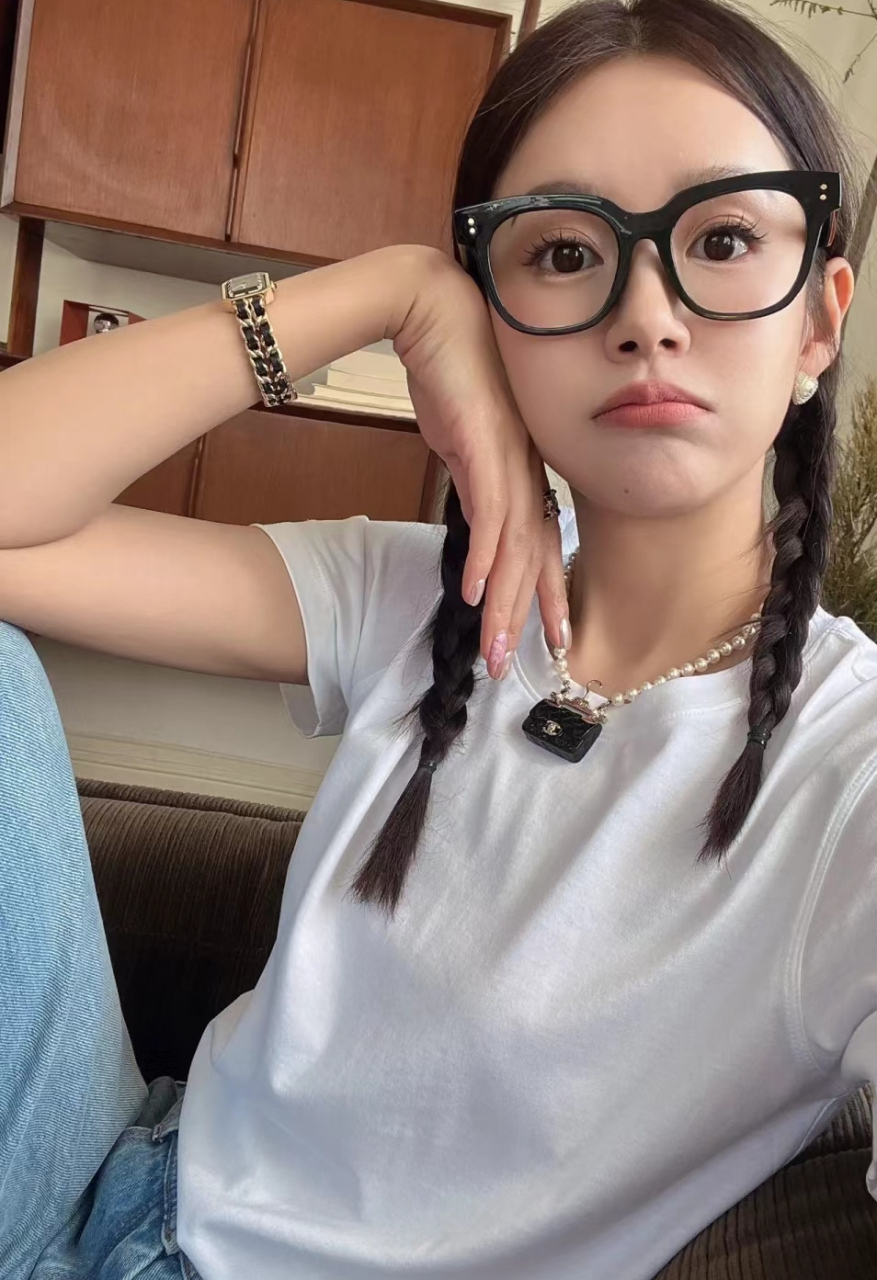 张子萱坐在沙发上自拍,戴着黑框眼镜像是学生,睫毛贴得太长,网红感太