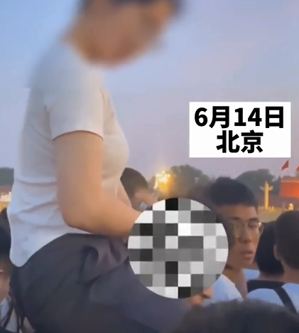 女子骑着男子脖子看升旗仪式,引发周围群众不满