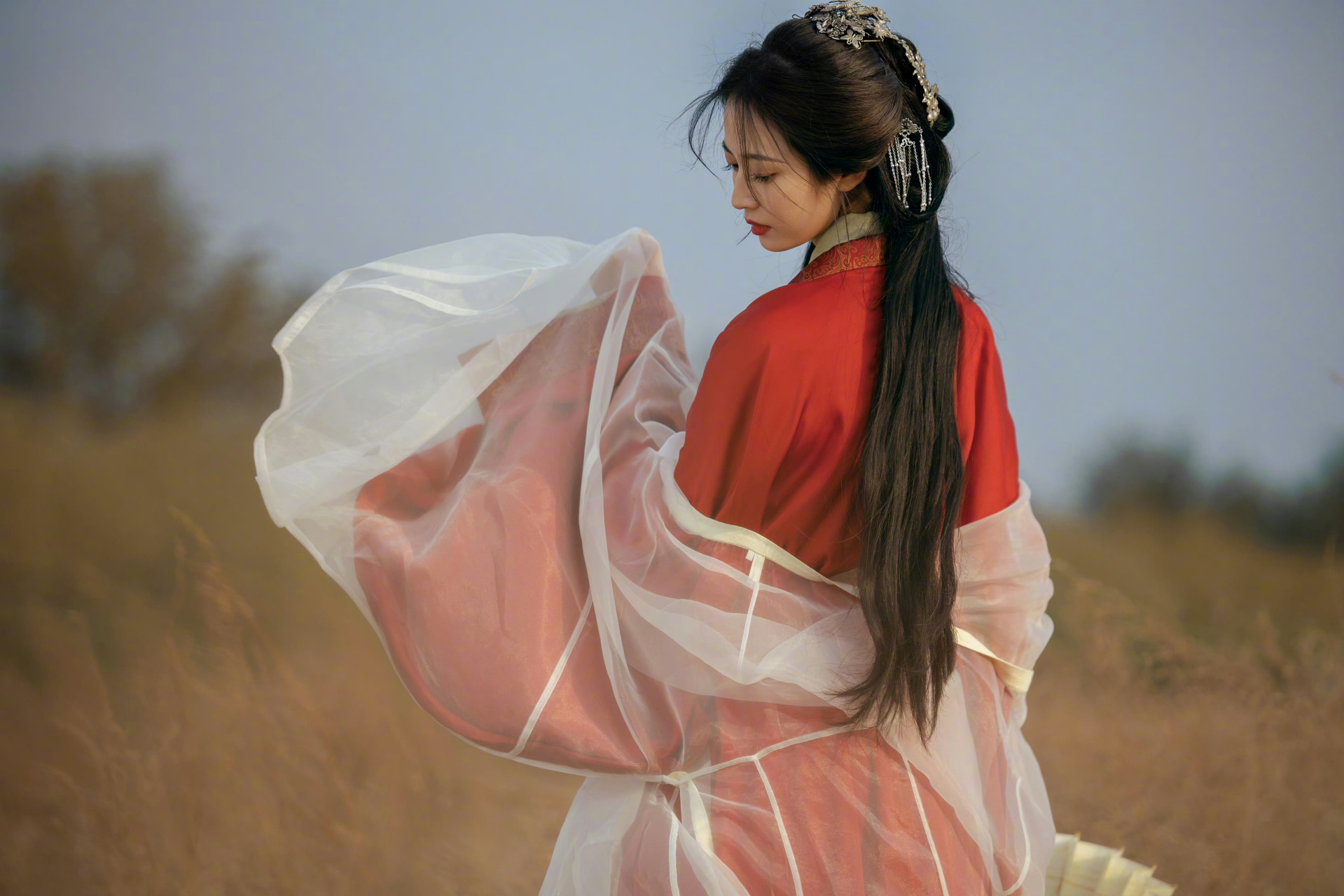 她穿着一袭红衣长衫,外面搭配着薄纱,看起来温婉又典雅.
