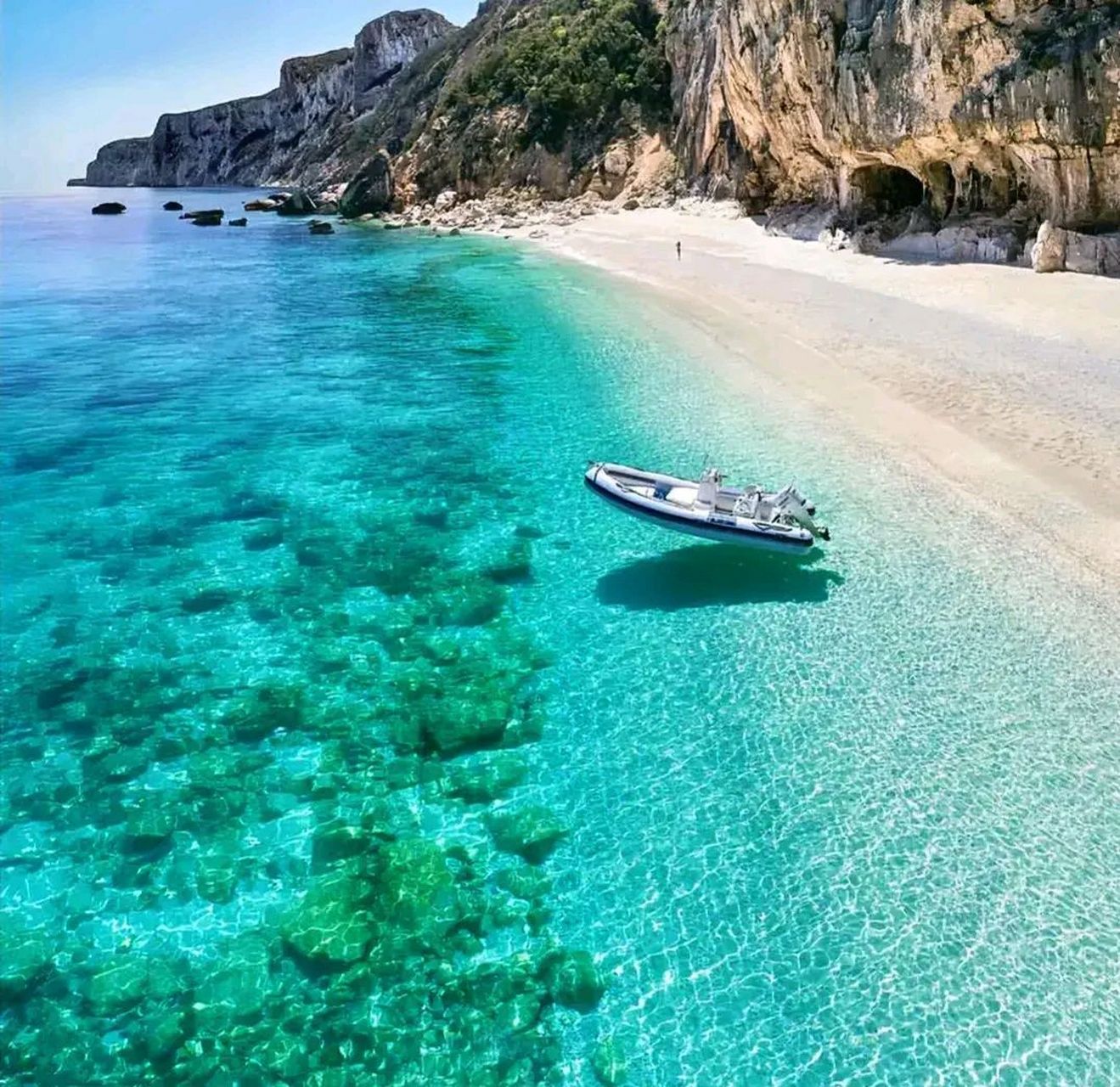 在清澈的海边,海水清澈见底,海面上泊着一艘皮艇,就象浮在空中一样