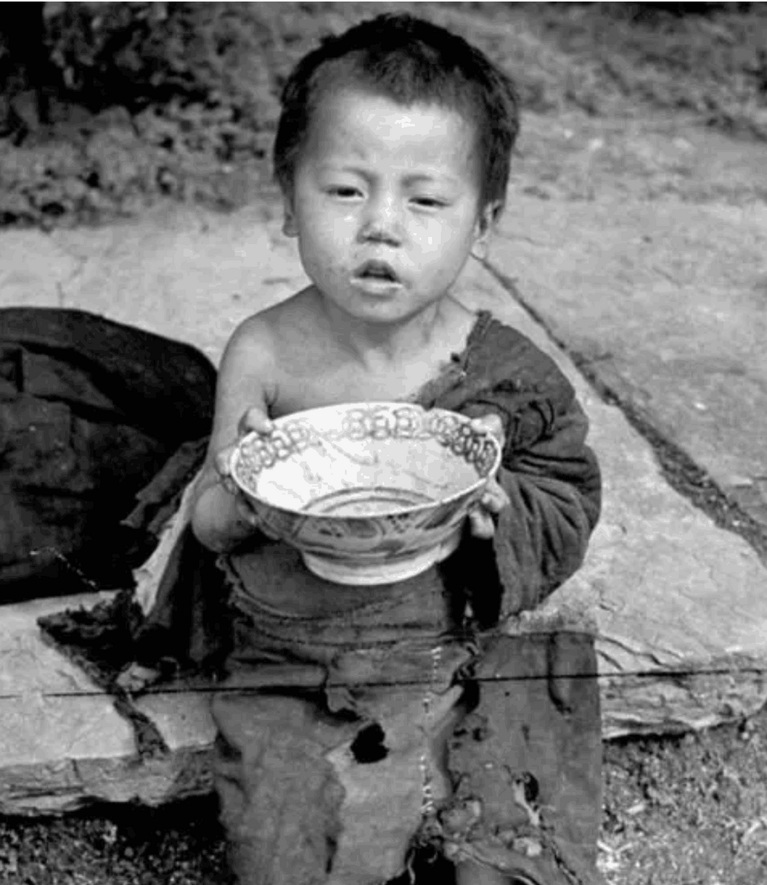 1942年河南大饥荒真实照片,一个小孩子拿着碗要饭刚好被国外摄影师拍