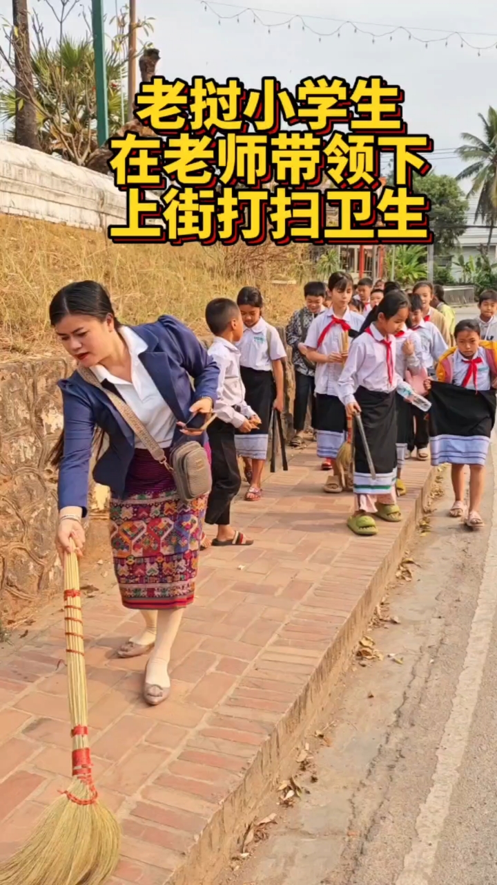 老挝小学生在老师的带领下,上街打扫卫生