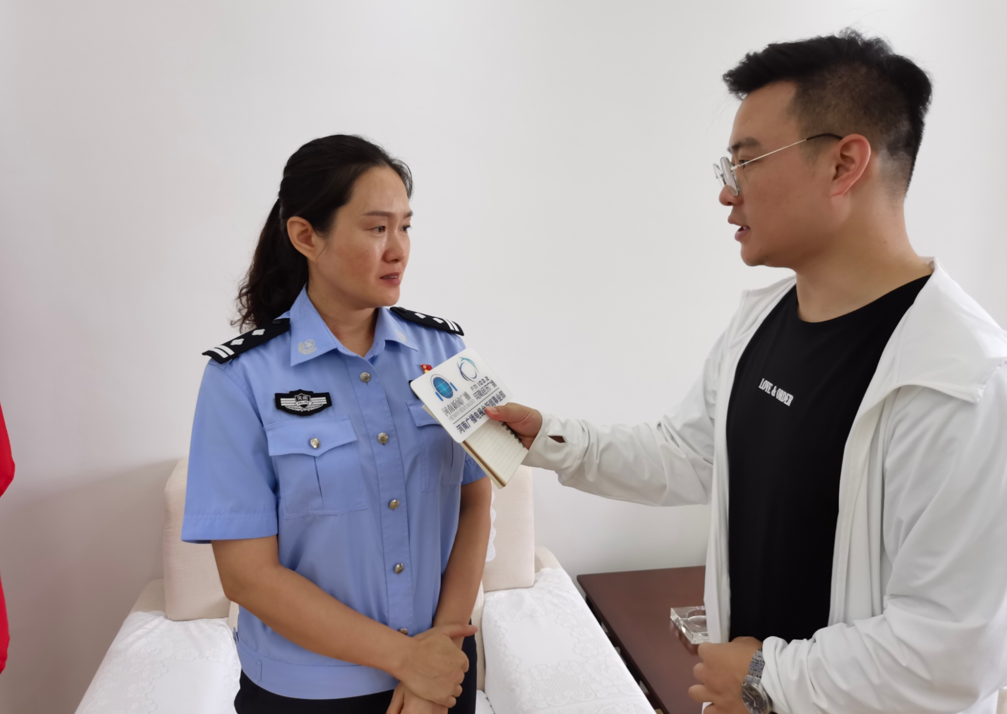 新密市公安局110指挥中心王晓钰(左)向记者讲述接警情形