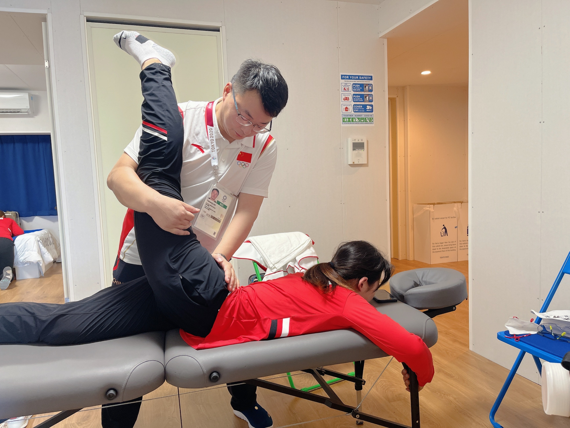 (↑队医廖远朋为运动员按摩治疗)