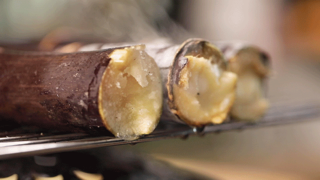 烤甘蔗是海南街边的热门小吃,整根甘蔗直接放在炭火上烤,烤完后趁着热