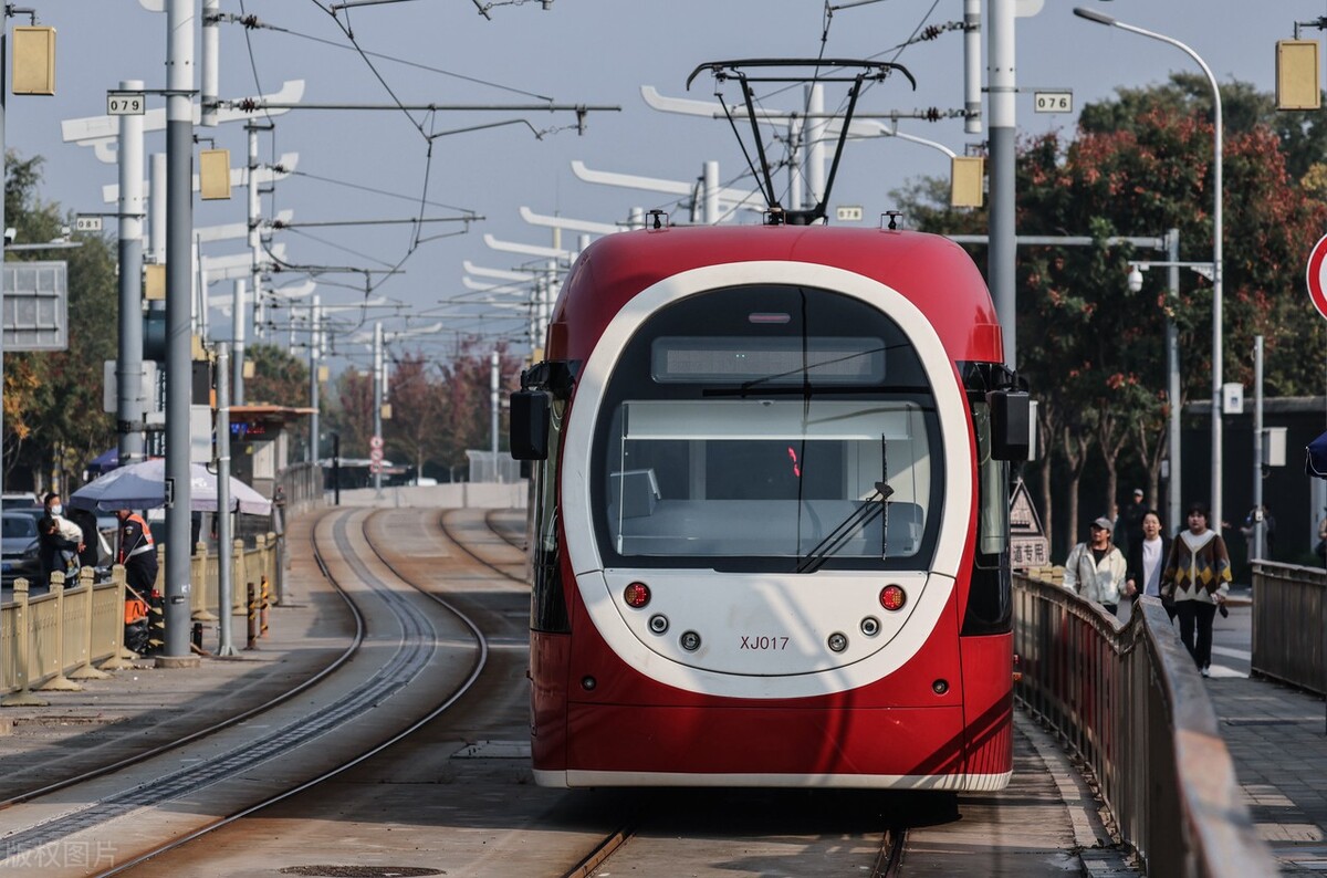 北京,地铁西郊线的列车在阳光的映照下驶入国家植物园站