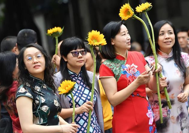 高考考场上的旗袍妈妈,手持鲜花,为孩子们祈求好运