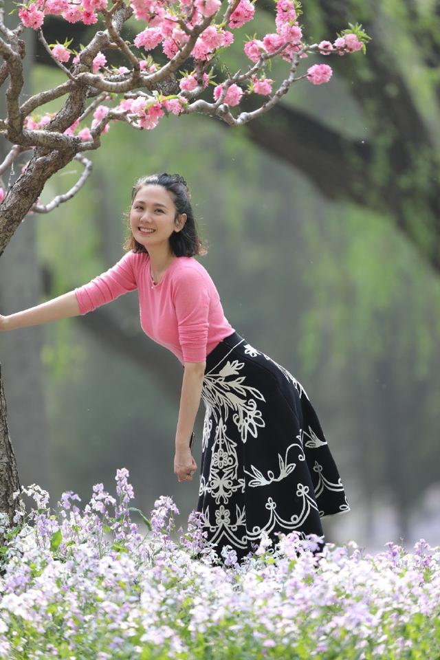 程莉莎针织衫搭配裙子,桃花树下状态真年轻,郭晓东真有福气