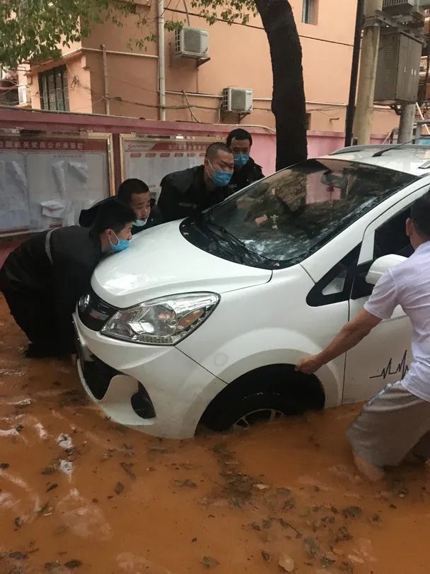 巡特警队员们在帮助群众救援被淹汽车
