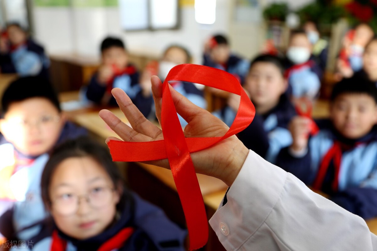 在塘沟小学教育集团,学生们在展示他们制作的防艾红丝带