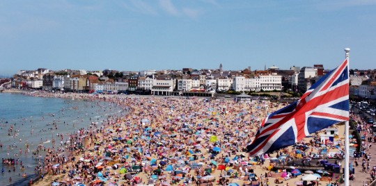 英国人涌向英国各地的海滩,在 30°c 的高温下晒太阳