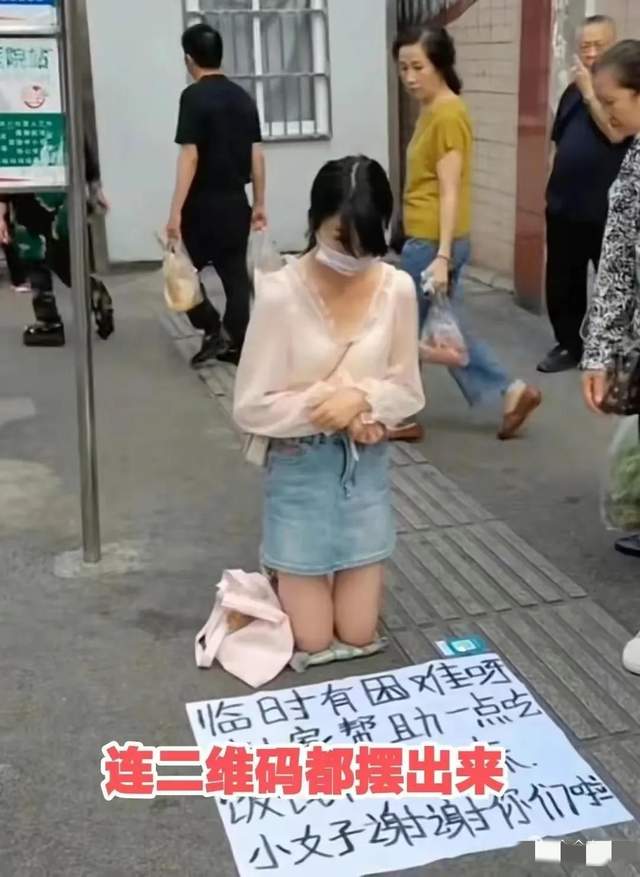 年轻女子穿着时尚当街跪地乞讨,有人擦肩而过,有人嗤之以鼻