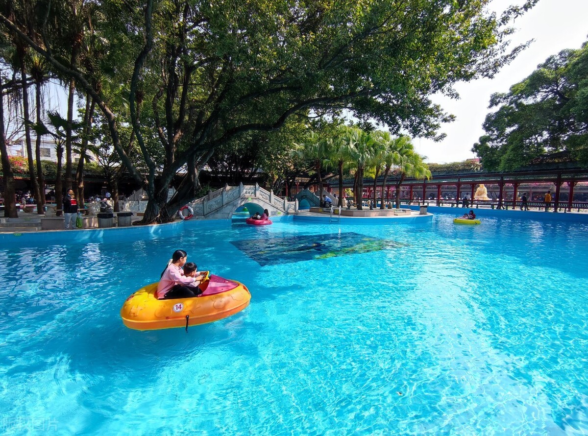 游人在广州番禺区"宝墨园"园林美景中乘坐水上碰碰船,尽情玩耍