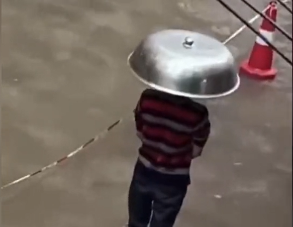 广西一男子头顶锅盖雨中排队做核酸,一旁冒雨执勤的大白令人破防