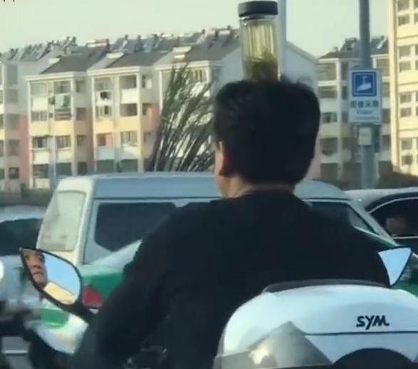 神操作!男子头顶茶杯骑车纠正驼背:不顶浑身难受
