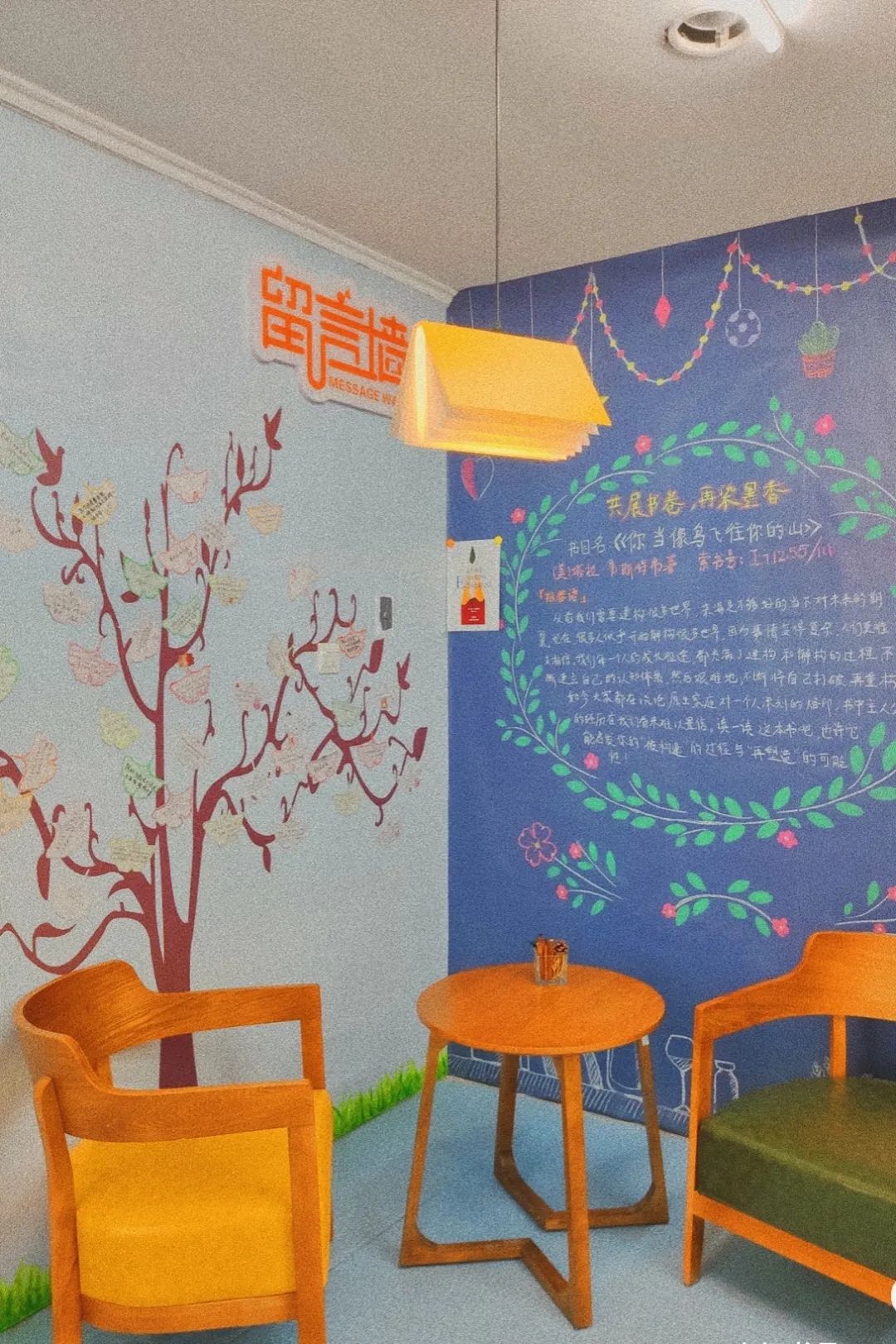 走上二楼,在拐角处是一面手绘黑板报和一面留言墙.