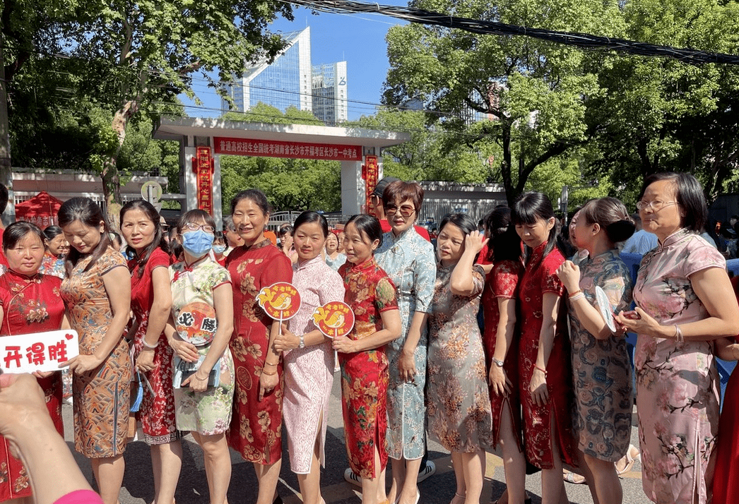 高考考场上的旗袍妈妈,手持鲜花,为孩子们祈求好运