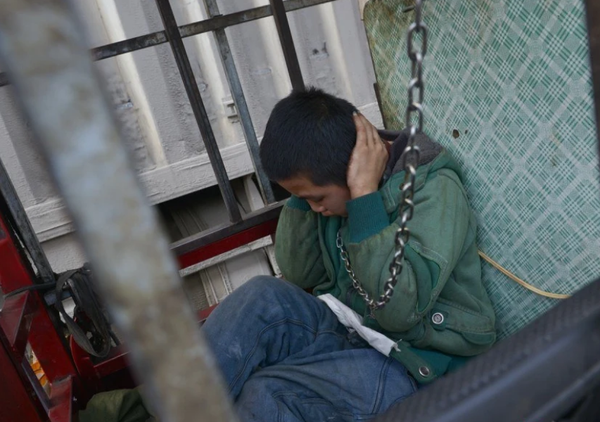 7岁少年关在铁笼被围观,男人麻木地作出解释:这是我儿子