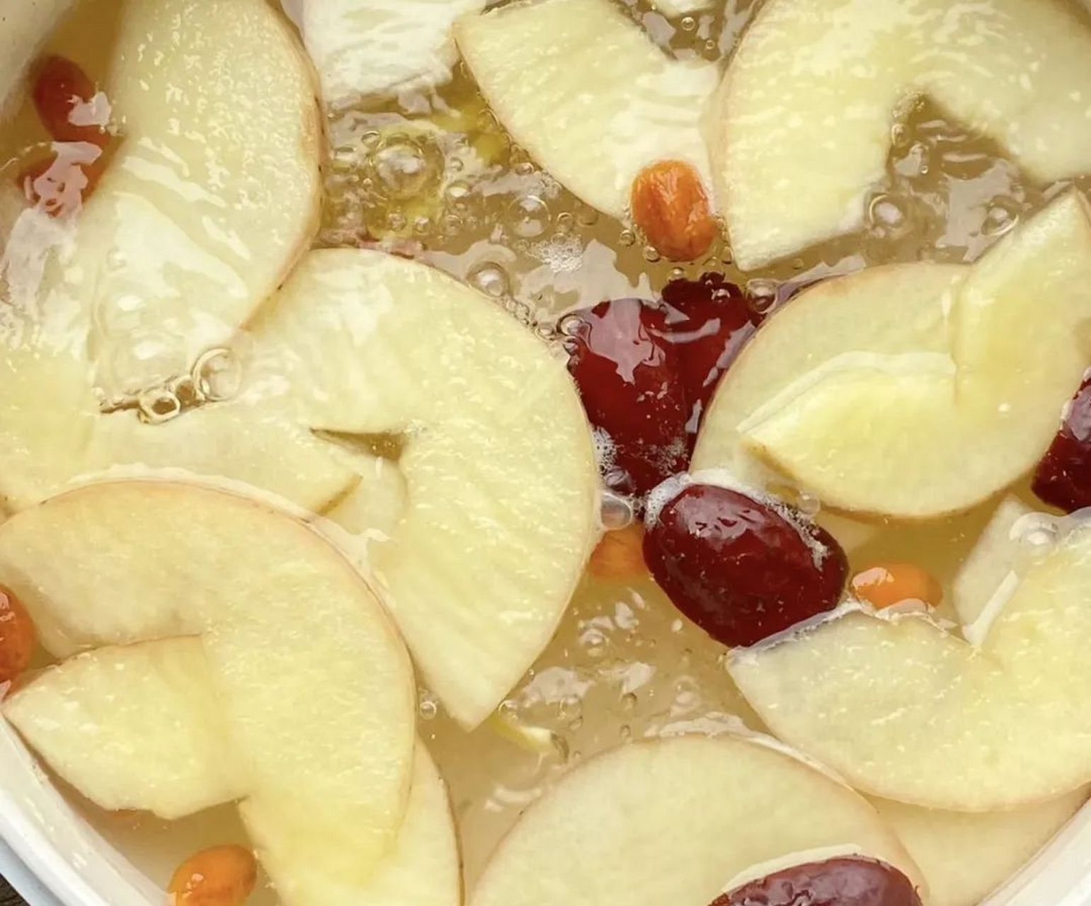 将苹果,生姜,红枣和枸杞煮水,煮沸后小火慢煮20分钟,倒入杯中冷却饮用