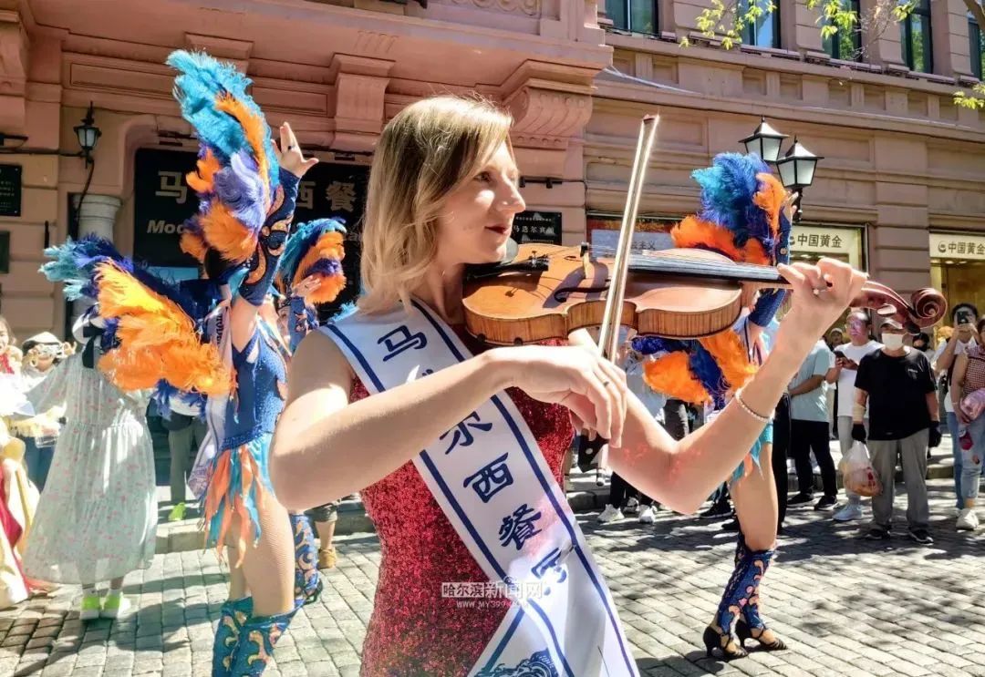 大街举行了盛大的花车和队伍巡游活动,市民和来哈游客与外籍演员拍照