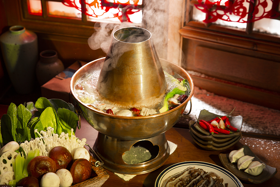 鱼,鸡等薄生片与菊花一起涮着吃,清香爽口,风味独特 云南的滇味火锅