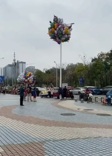 广西南宁:大叔售卖的气球不慎飞走挂路灯上,徒手爬路灯杆想取回