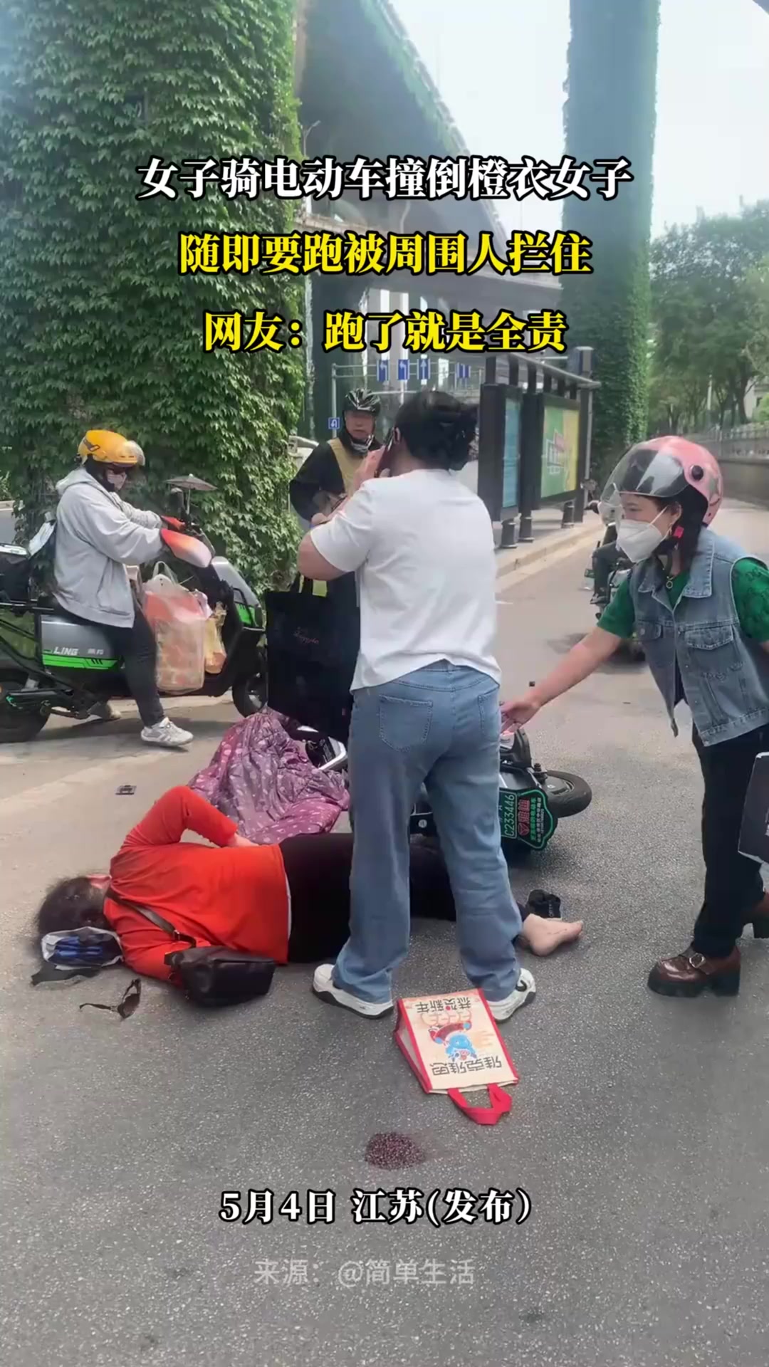 女子骑电动车撞倒橙衣女子,随即要跑被周围人拦住