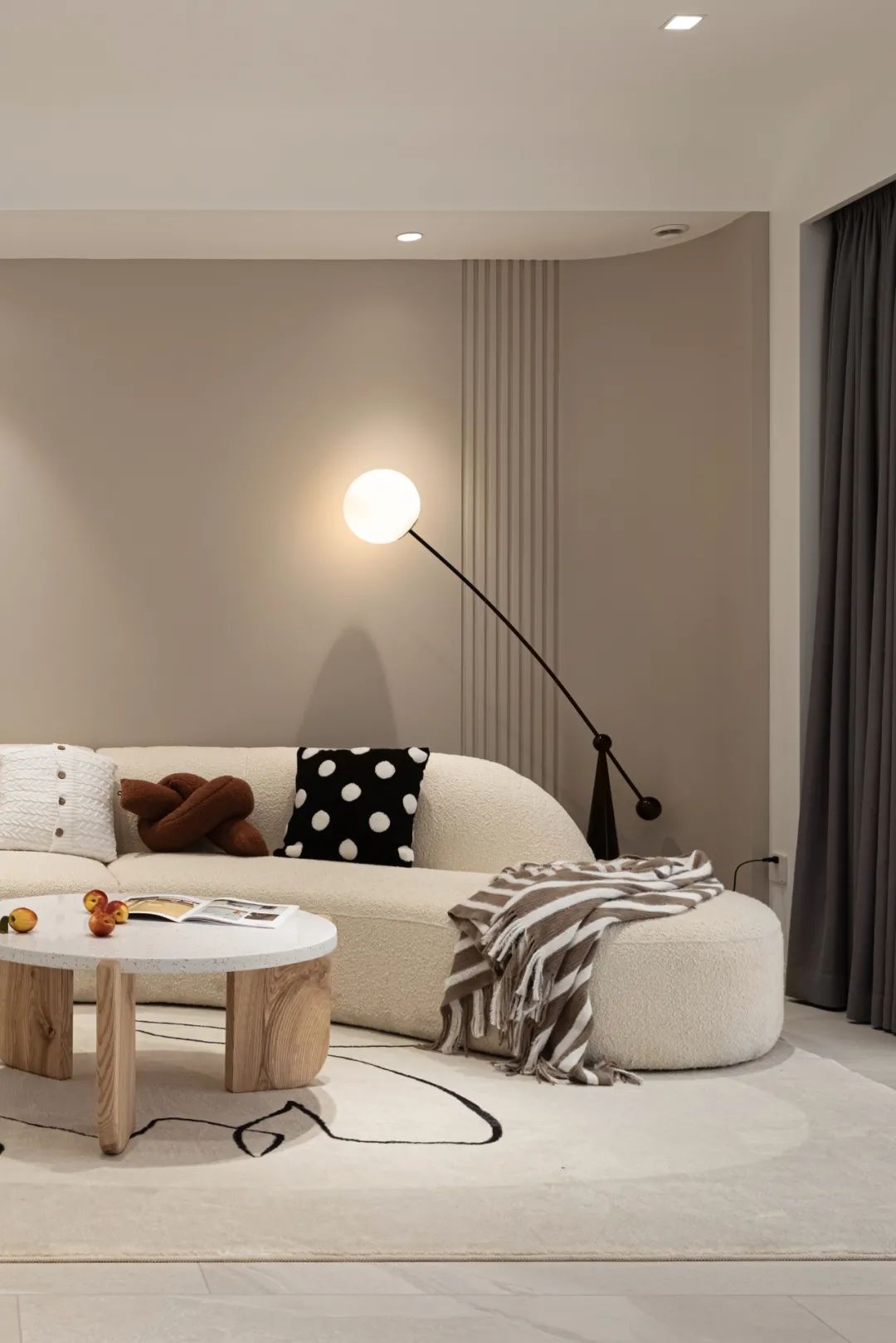 沙发背景墙弧形设计,雅致有趣,灰粉色调搭配个性落地灯,柔和有情调.