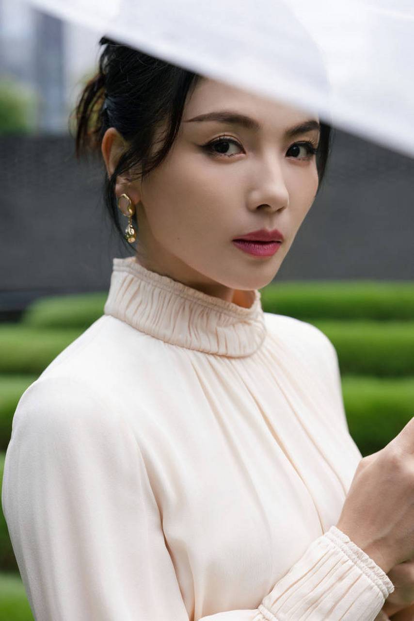 刘涛身穿白裙优雅撑伞 盘发漫步展现知性魅力